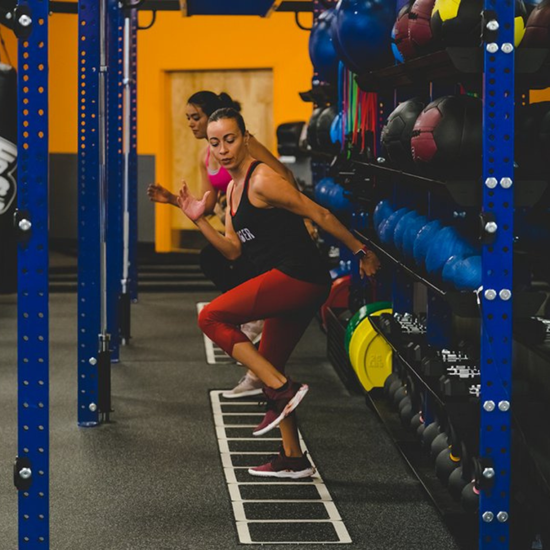 An image of two women performing ladder drills at Crunch Fitness center in Evansville, IN