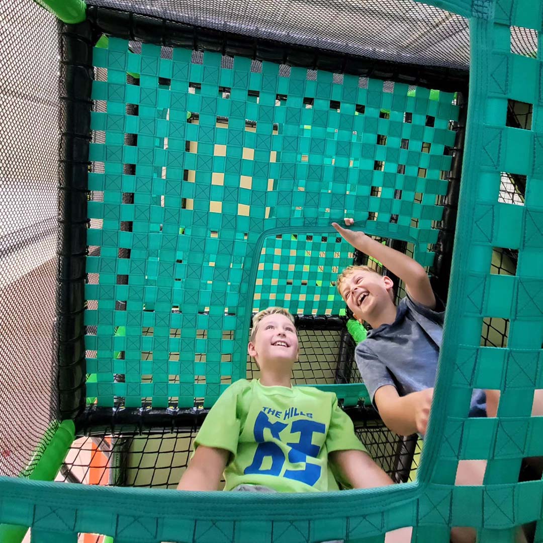 An image of two young boys playing at the Hills Church Community Center playscape