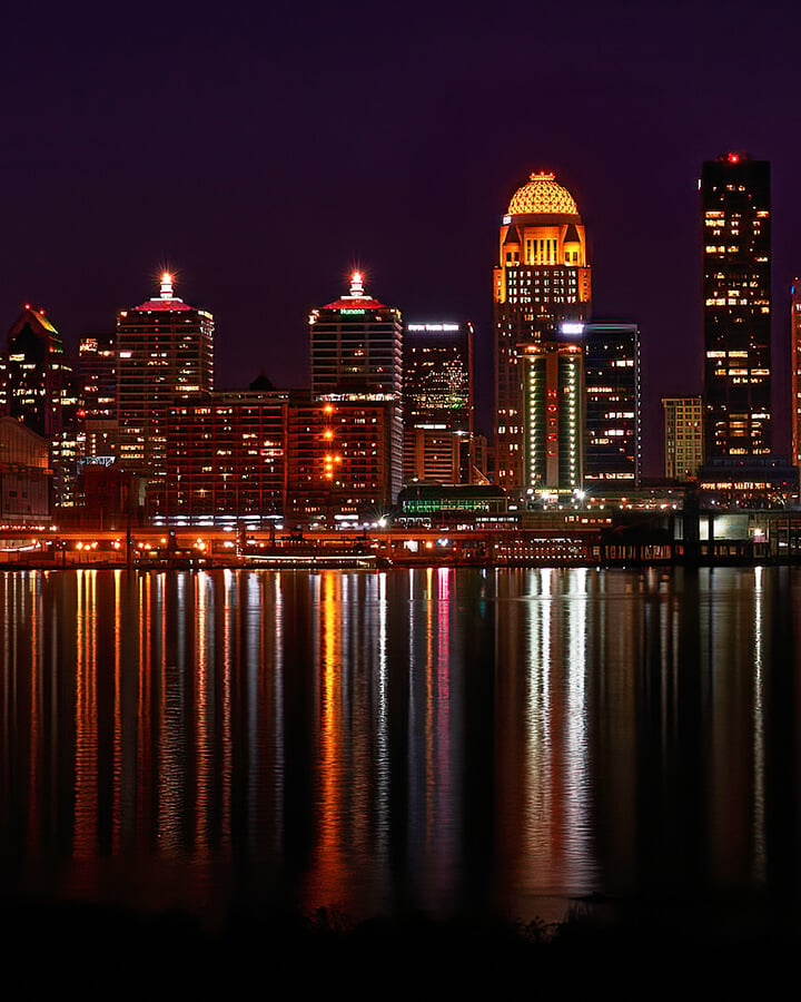 A night time image overlooking the downtown skyline and riverfront in Louisville, KY