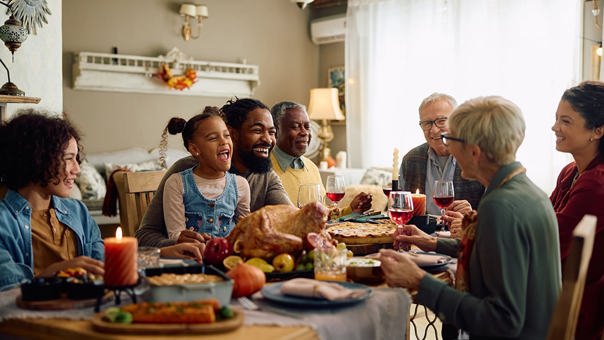 A family gathers around a dinner table for a holiday meal together